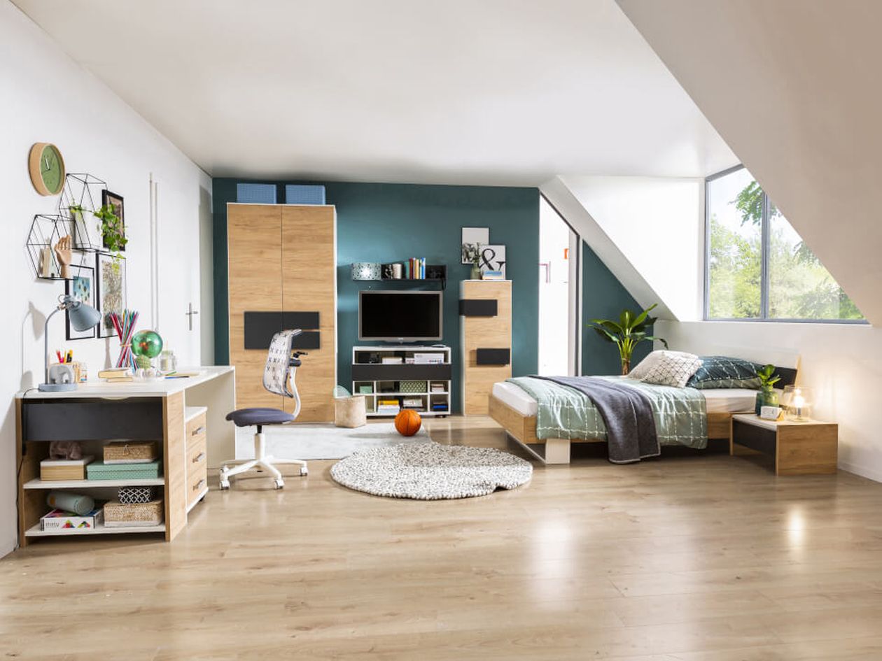 Modernes Schlafzimmer mit Holzmöbeln, Bett, Schreibtisch und Bücherregal. Heller Holzboden, türkisfarbene Akzentwand und großes Fenster mit Blick ins Grüne.