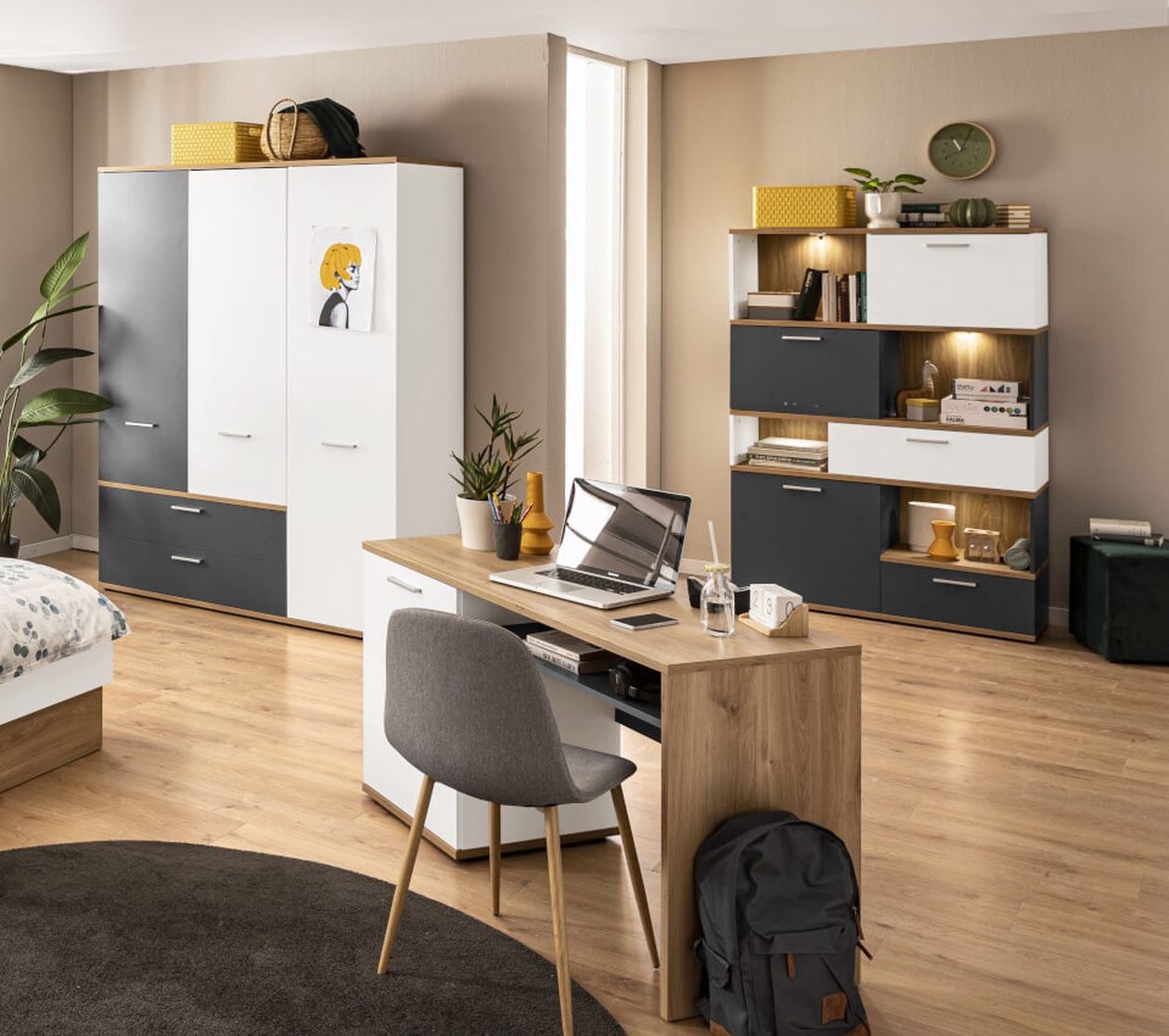 Modernes Schlafzimmer mit Schreibtisch, Laptop, Stuhl, Regalen und Kleiderschrank. Neutrale Farbtöne, Pflanzenakzente und natürliches Licht schaffen eine gemütliche Atmosphäre.
