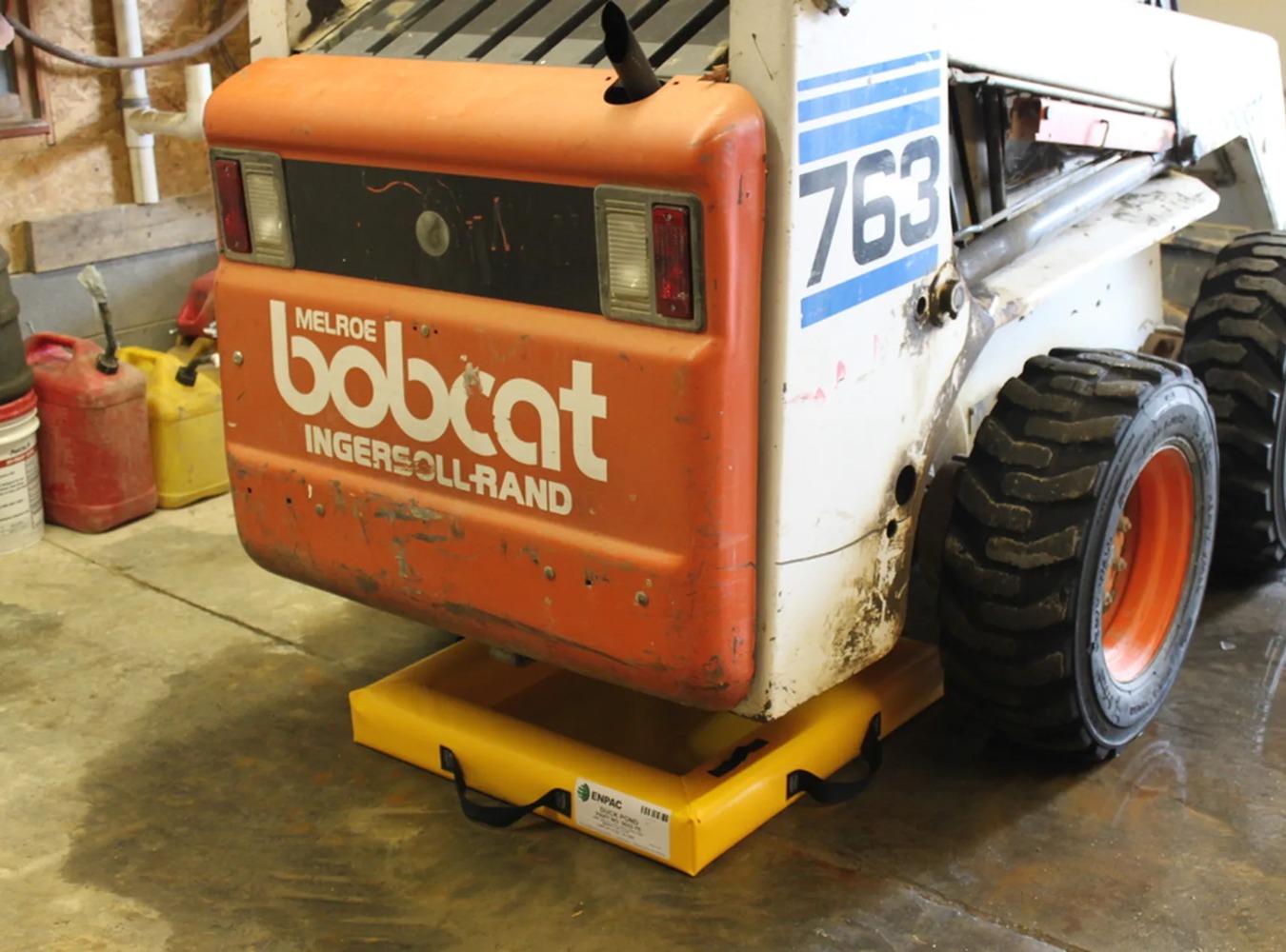 a black and yellow spill pad under a forklift