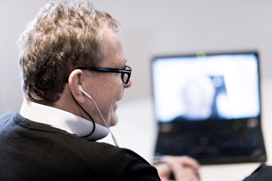 Affärsmannen dricker kaffe och får online-coachning vid sin dator