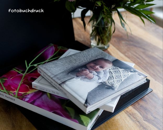 YAY-Fotobücher auf einem Holztisch