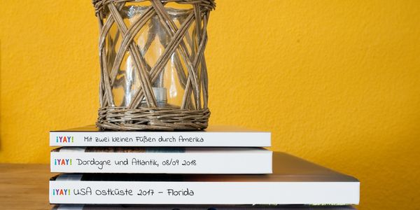 Ein Stapel YAY-Fotobücher mit Windlicht