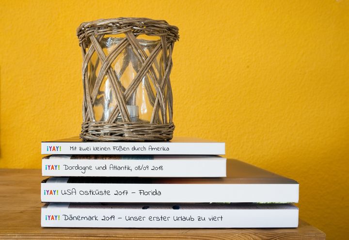 Ein Stapel YAY-Fotobücher mit Windlicht