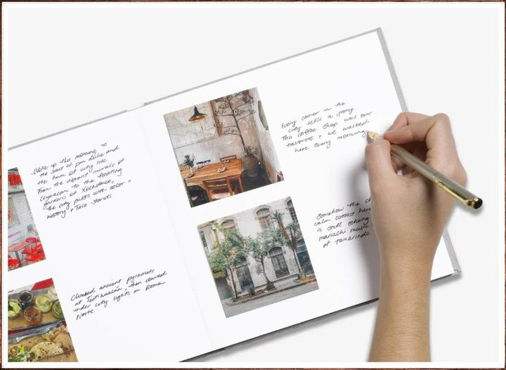 Eine Hand schreibt mit einem Stift in ein YAY-Fotobuch