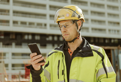 Constructionworker looking at phone