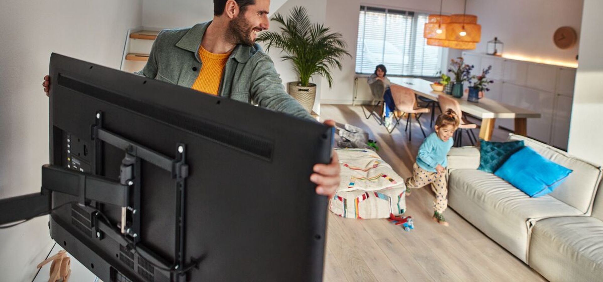 Dad turning the safe TV wall mount, COMFORT | Vogel's