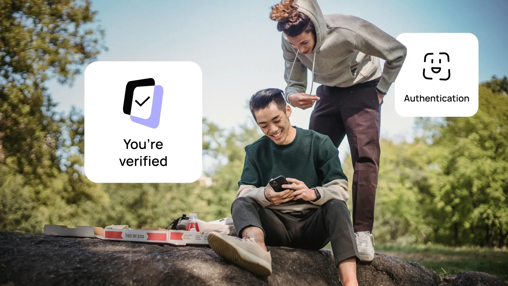 Two people outdoors, one sitting using a smartphone, with overlay text showing "You're verified" and "Authentication" symbols. Pizza boxes nearby.