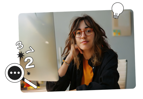 A person with glasses and long hair sits at a desk, resting their chin on their hand, looking at a computer screen with doodles around.