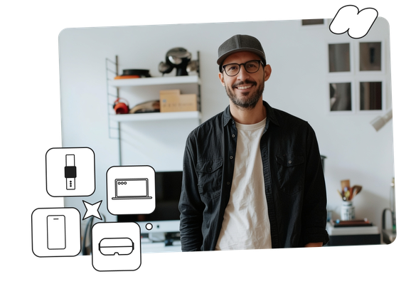 A smiling man with glasses and a cap stands in a modern office. Floating icons of a USB, laptop, smartphone, and VR headset are near him.