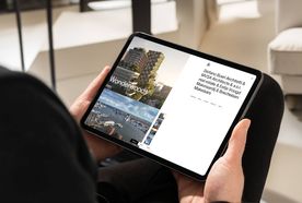Person holding a tablet displaying architectural project "Wonderwoods" with images of cityscapes and text detailing architects and real estate partners.