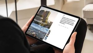 Person holding a tablet displaying architectural project "Wonderwoods" with images of cityscapes and text detailing architects and real estate partners.