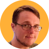 A person with glasses, short hair, and a slight smile against an orange background.