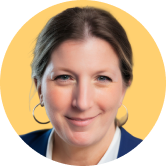 Headshot of Andi Robinson. Smiling woman with hoop earrings and a blazer, set against a solid yellow background