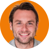 Smiling man with short hair and stubble, in front of an orange circular background.