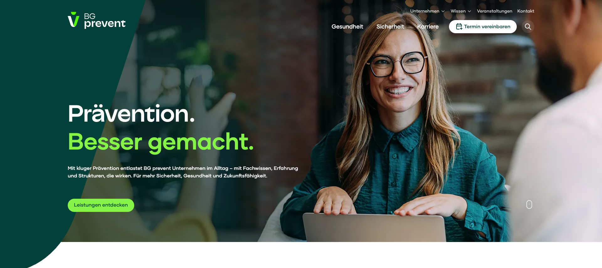 Screenshot of the BG Prevent website homepage. The page features a smiling woman in glasses and a green shirt working on a laptop, with the headline “Prävention. Besser gemacht.” in bold green and white text. The navigation menu includes links to Gesundheit, Sicherheit, Karriere, and more, and there’s a green button labeled “Leistungen entdecken.” The BG Prevent logo appears in the top left corner.