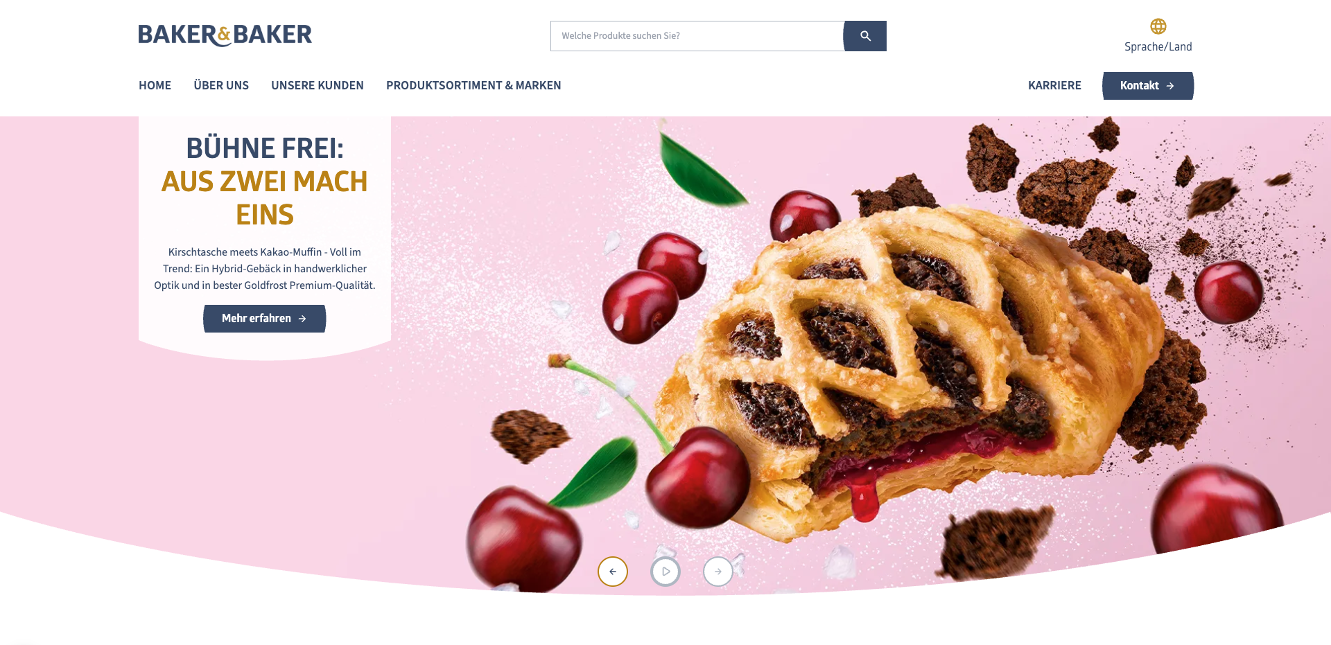 Homepage of the Baker & Baker Germany website featuring a large banner. On the left, bold text reads “Bühne frei: Aus zwei mach eins,” with a description of a hybrid pastry combining cherry filling and cocoa muffin flavors, and a button labeled “Mehr erfahren.” On the right, a close-up image shows a flaky pastry filled with chocolate and cherry, surrounded by floating cherries, chocolate crumbs, and powdered sugar against a pink background. The top navigation includes links for Home, Über uns, Unsere Kunden, Produktsortiment & Marken, Karriere, and Kontakt, along with a search bar and a language selector.