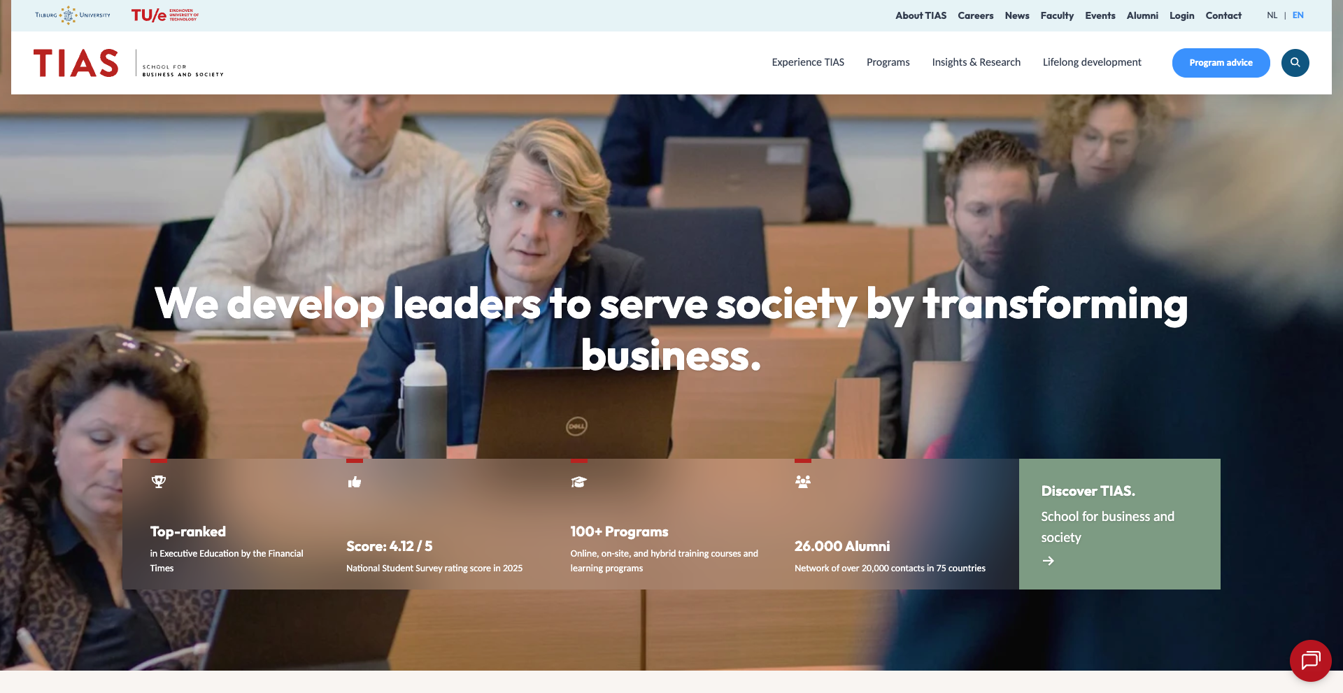 People sitting in a lecture room, focused on a speaker. The screen displays "We develop leaders to serve society by transforming business."