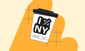 Coffee cup with "I NY" design, black lid, and logos of Storyblok and 360i on a yellow and beige background with abstract shapes.