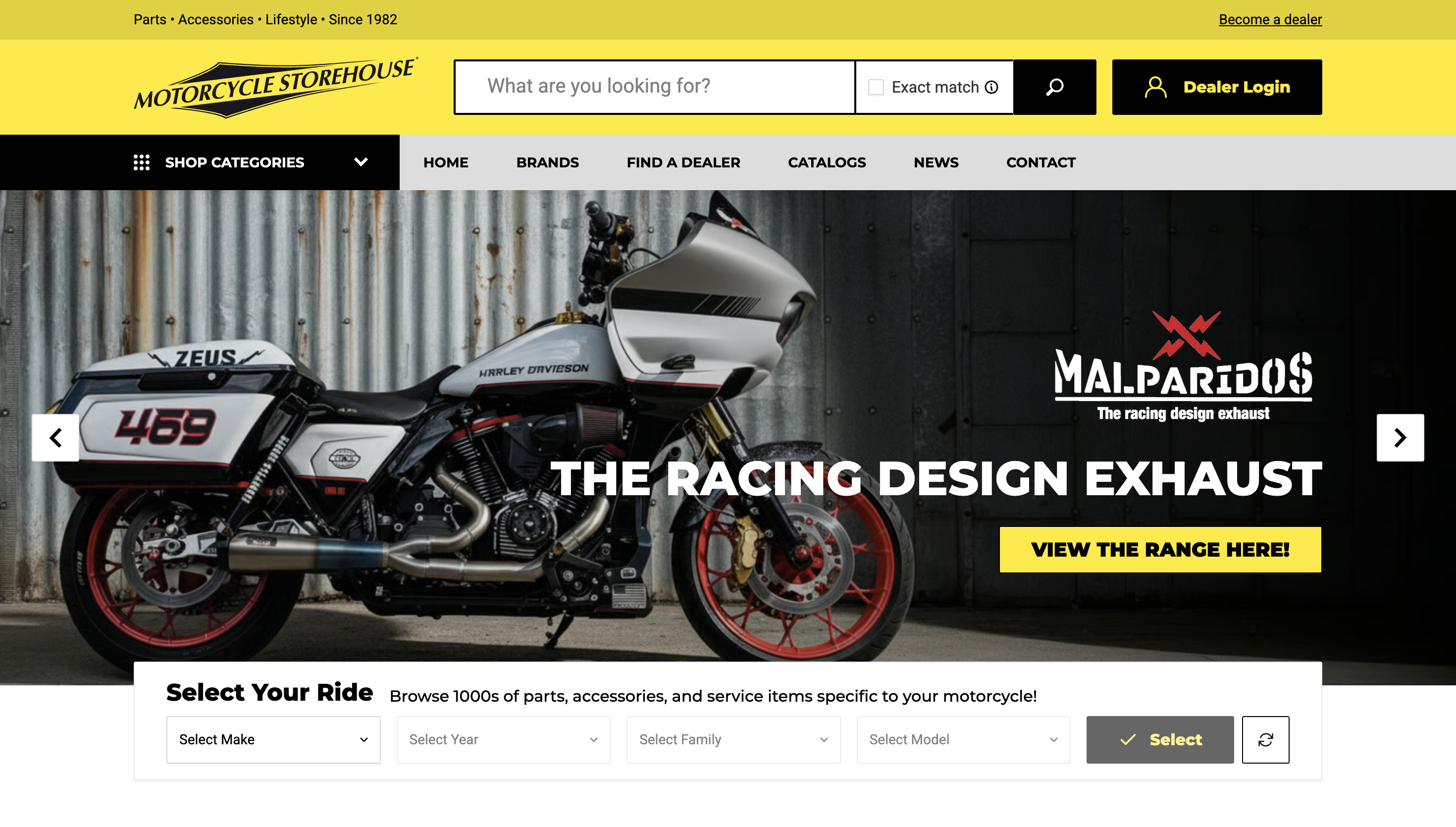 A black and white motorcycle displayed on a website promoting “THE RACING DESIGN EXHAUST.” Yellow highlight on "View the Range Here!"