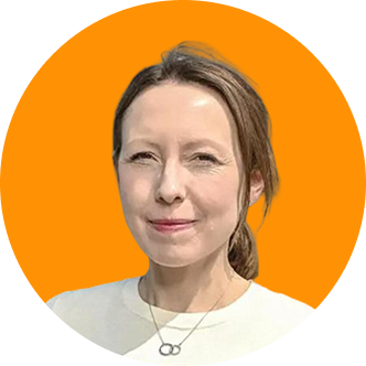 Smiling woman with long hair tied back, wearing a white top and necklace, against an orange background.