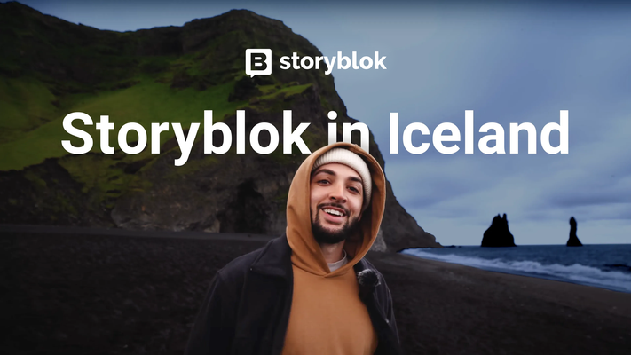 A person smiling on a black sand beach with rocky cliffs in Iceland, overlaid text "Storyblok in Iceland."