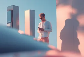 Man in sunglasses checking phone near modern columns, casting a shadow on a pink-tinted wall.