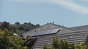 A photo of a house with a solar panel on its roof
