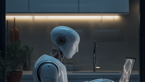 A humanoid robot sits at a table in a dimly lit kitchen, focused on a laptop. A potted plant is nearby.