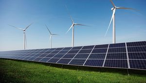 Solar panels and wind turbines on a grassy field under a clear blue sky, illustrating renewable energy sources.