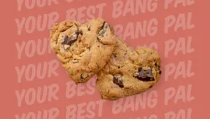 Two chocolate chunk cookies on a pink background with repeated text "YOUR BEST BANG PAL."