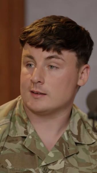 Man in military uniform with short brown hair, looking sideways.