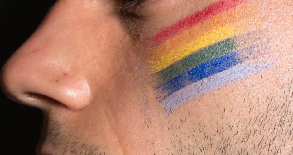 Face with pride flag painted on
