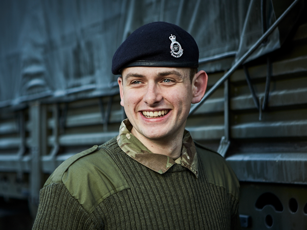 Young officer smiling in front of vehicle