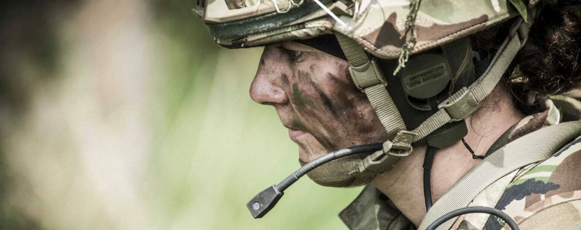 female soldier with camo paint and headset