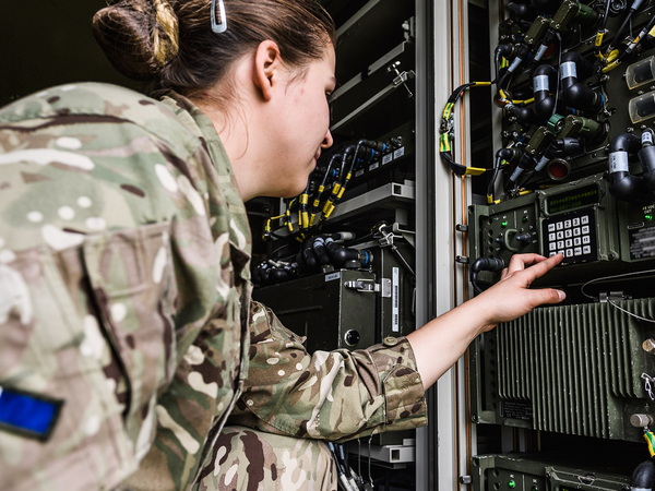 Female soldiers looking at a network box