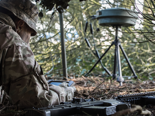Solider in the field working with signal equipment