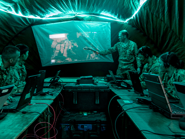 Team of Signal soldiers in a tent listening to briefing