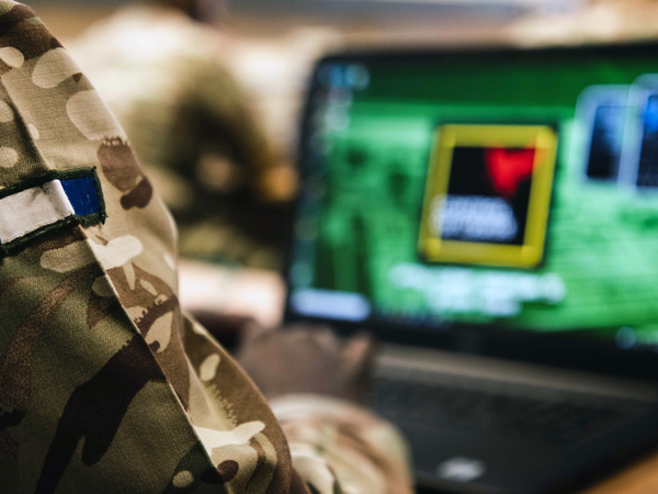 Closeup of a Signals soldiers badge as they focus on a computer screen