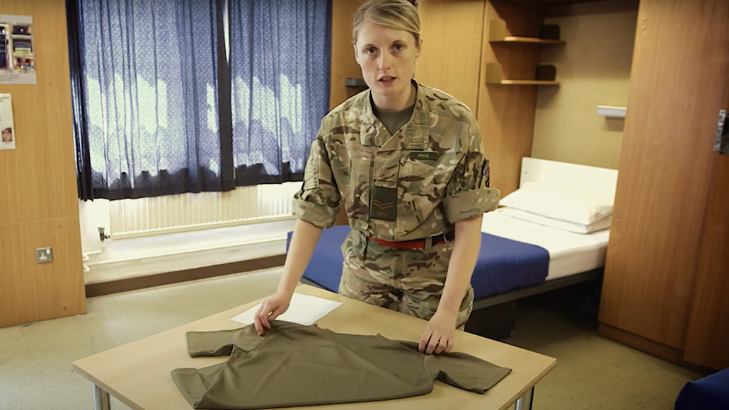 Female soldier ready to fold a tshirt