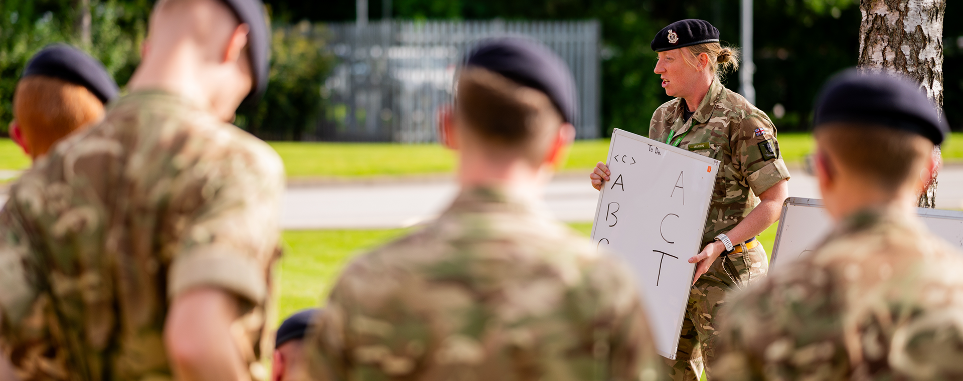 Junior soldiers outside listening to briefing by a superior