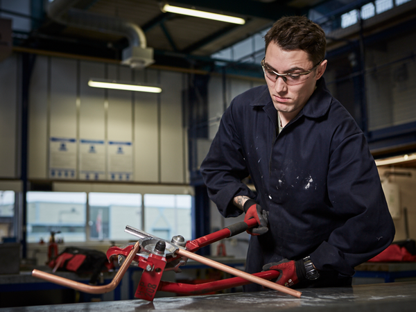 Soldier in workshop working on a copper pipe