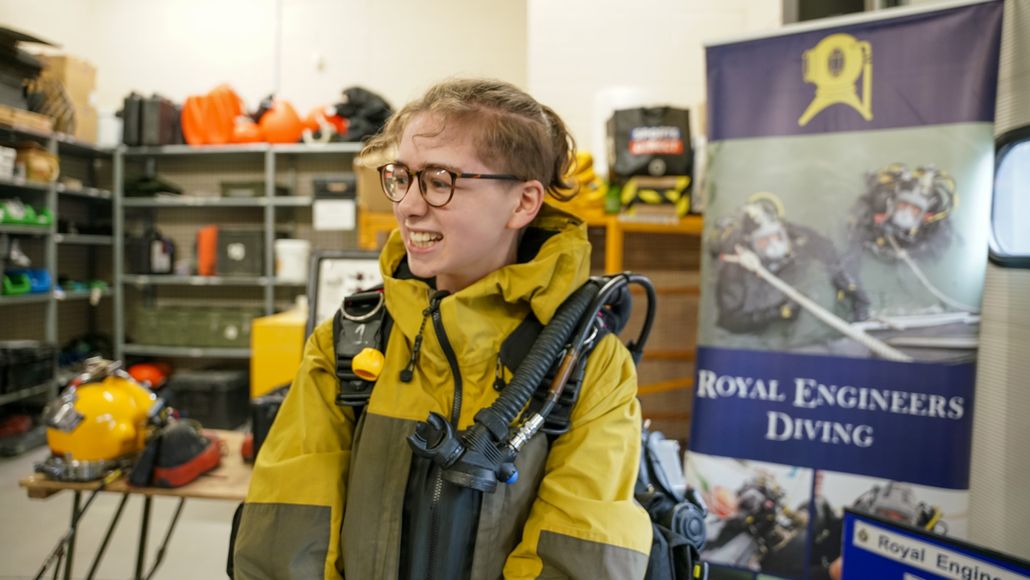 Student trying on diving gear with Royal Engineers Diving graphic in the background