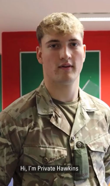 A soldier in camouflage uniform stands indoors, identified as Private Hawkins, with a red and green background.