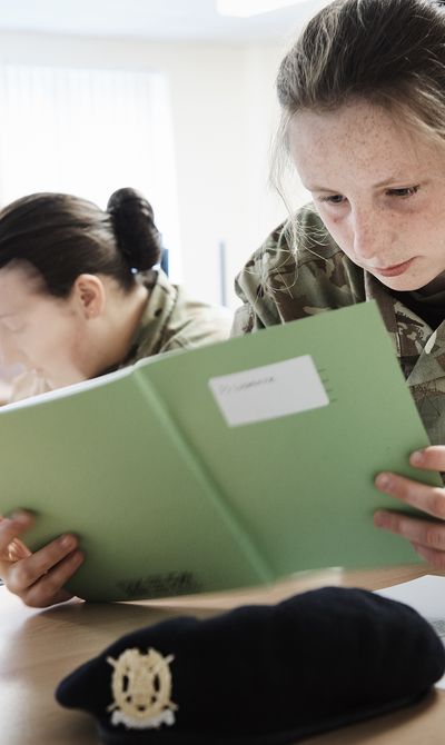 Girl in classroom reading a notebook