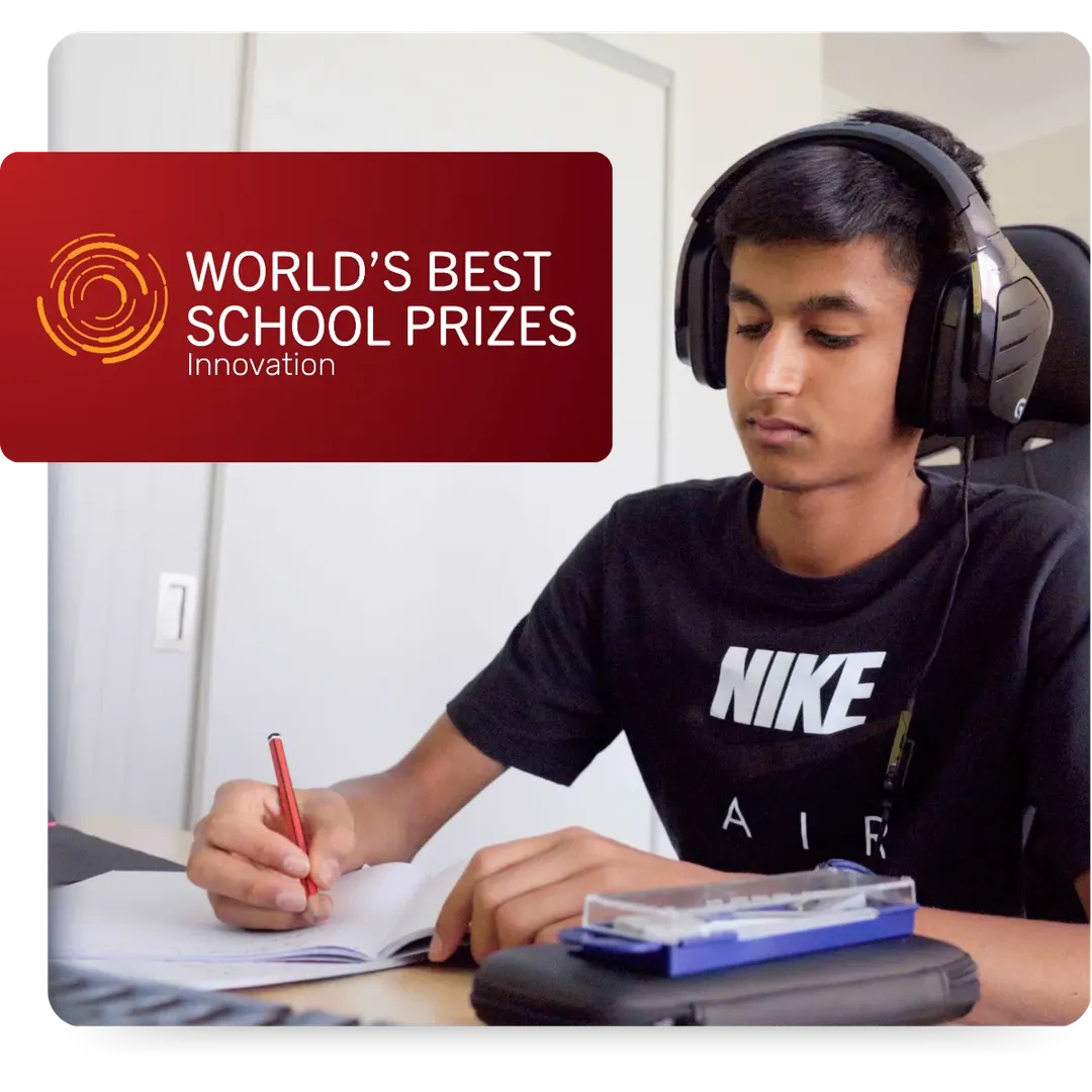 CGA Student writing down and wearing headphones while in online class