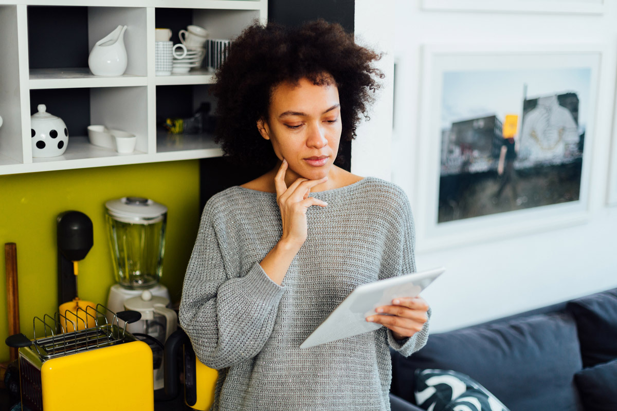 A woman looking at a tablet, concentrating