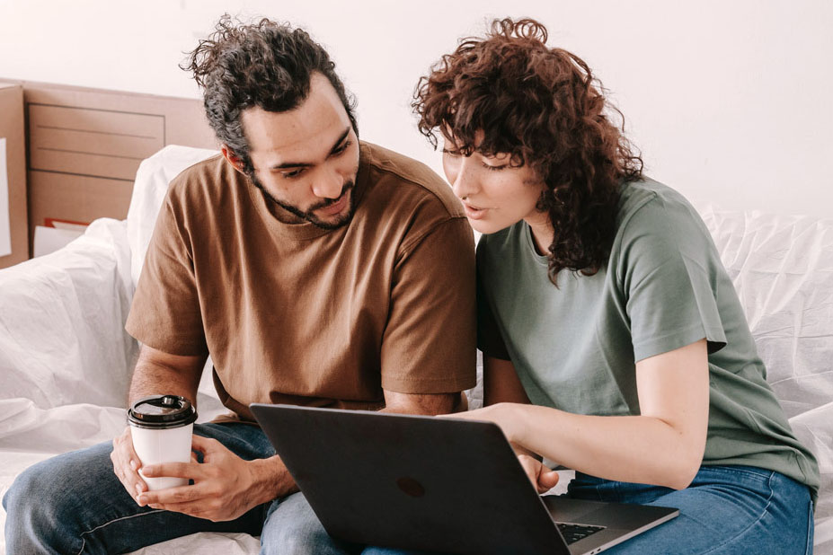 A couple checking their bills on a laptop