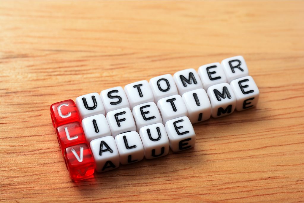 dice letter arranged to show the word customer lifetime value placed on top of brown table