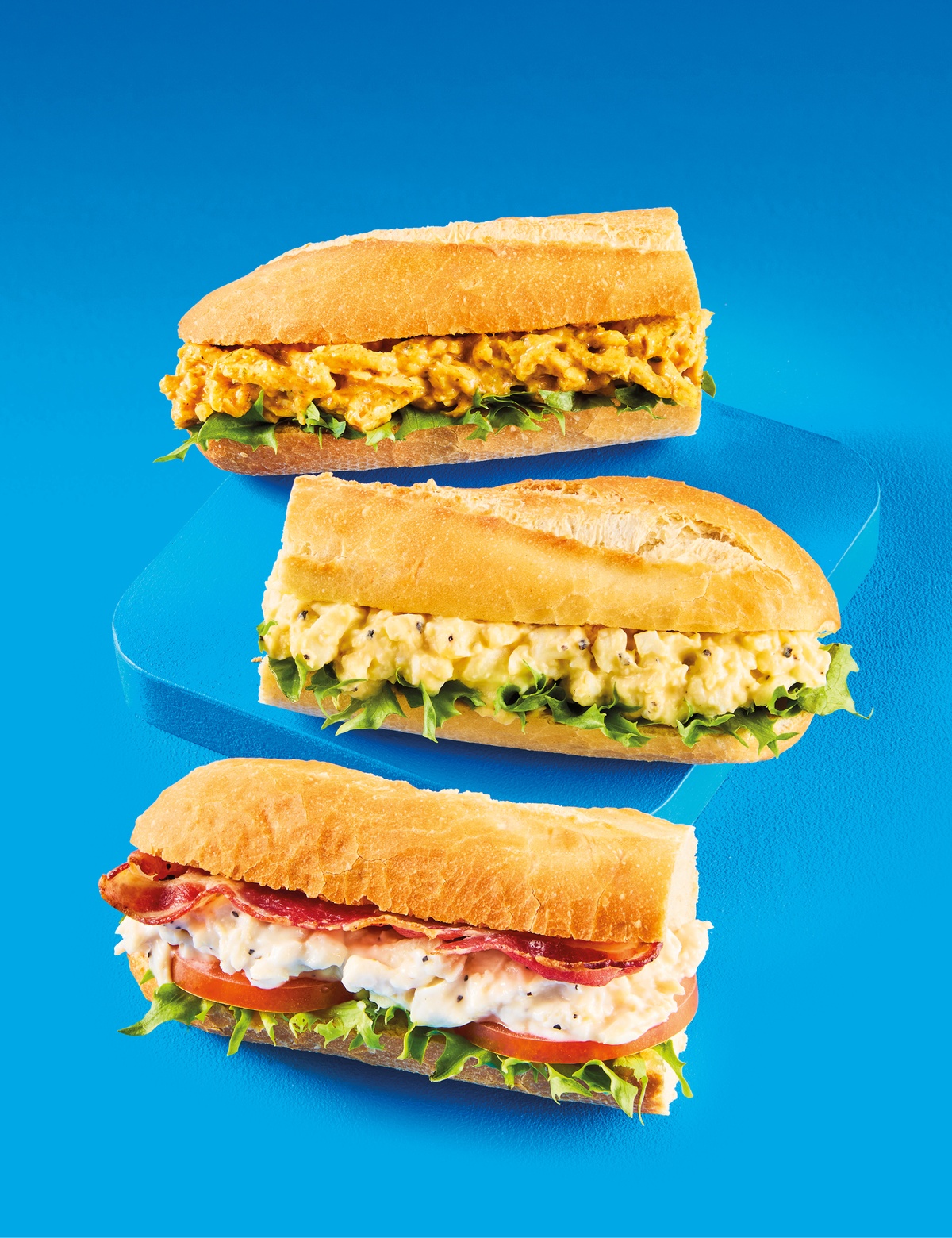 Three half baguettes on a blue background