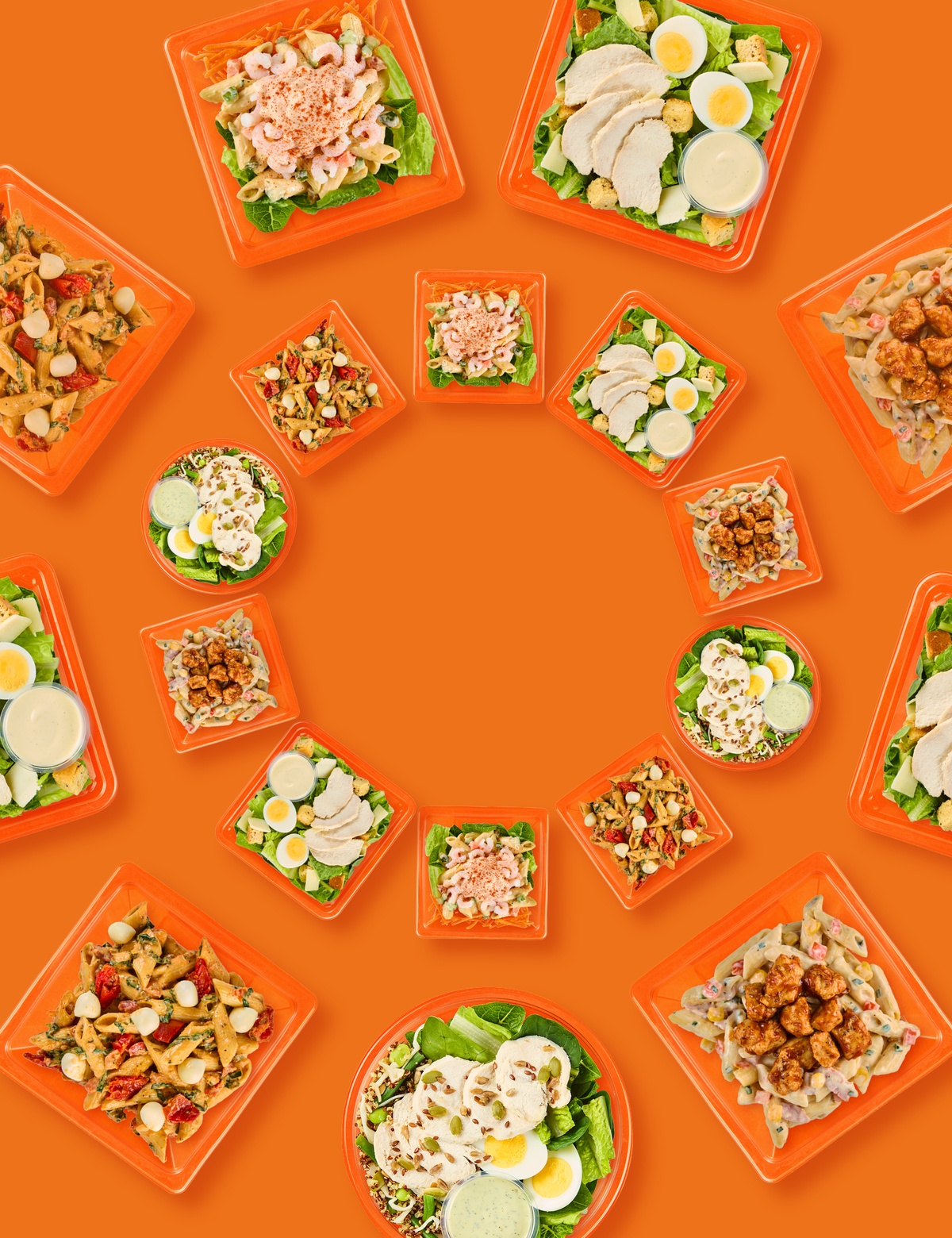 A range of salads splayed on an orange background in a kaleidoscope shape